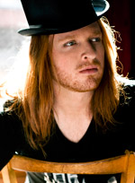 Red curly hair, sometimes unshaven, casual leather jacket, black cap, scarf, t-shirt, jeans and XXL bracelets – this young man could easily pass for a true ... - marc-angers-mot